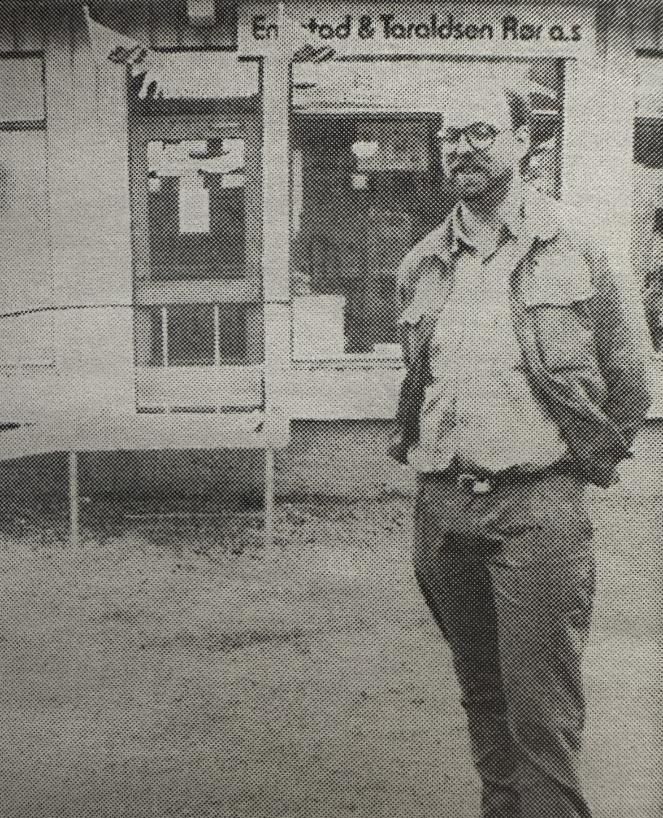 Mann som står utenfor foran butikkvindu